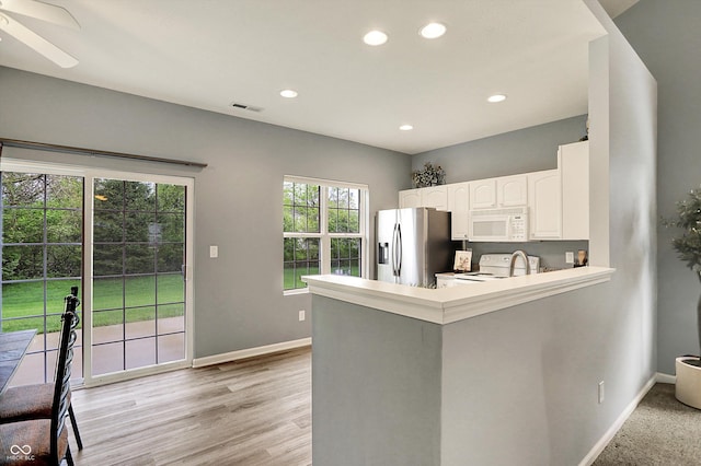 kitchen featuring visible vents, white appliances, baseboards, recessed lighting, and white cabinetry