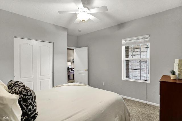carpeted bedroom featuring a closet, baseboards, and ceiling fan