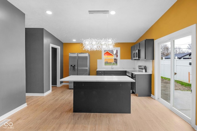 555 N Hamilton Ave, Indianapolis, IN 46201 - kitchen featuring light countertops, a center island, light wood-style floors, a notable chandelier, and appliances with stainless steel finishes