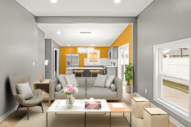 555 N Hamilton Ave, Indianapolis, IN 46201 - living room featuring a wealth of natural light, light wood-type flooring, baseboards, and a chandelier