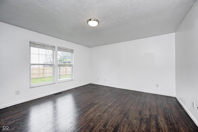 6036 Terrytown Pkwy, Indianapolis, IN 46254 - spare room with visible vents, dark wood-style floors, baseboards, and a textured ceiling
