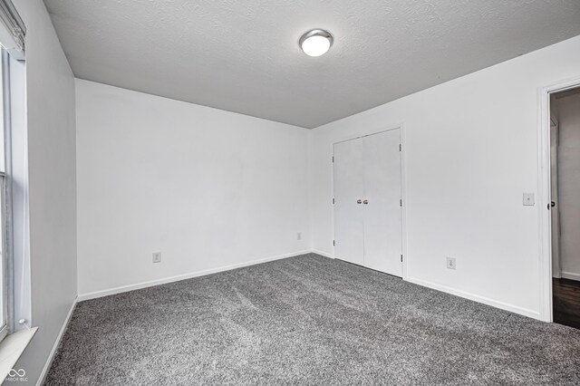 6036 Terrytown Pkwy, Indianapolis, IN 46254 - spare room featuring baseboards, a textured ceiling, and dark carpet