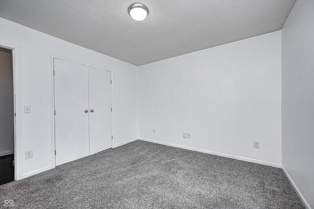 6036 Terrytown Pkwy, Indianapolis, IN 46254 - unfurnished bedroom with baseboards, a closet, dark colored carpet, and a textured ceiling