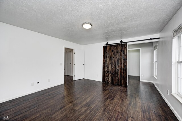 6036 Terrytown Pkwy, Indianapolis, IN 46254 - unfurnished room featuring dark wood finished floors, baseboards, and a barn door