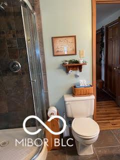 full bath featuring toilet and a shower stall