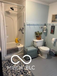 bathroom featuring shower / tub combo with curtain and toilet