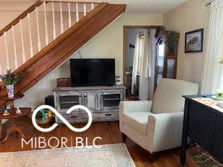 living room with wood finished floors and stairs