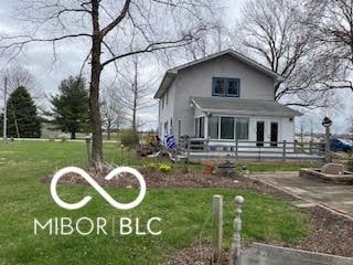 view of front of property with a deck and a front lawn