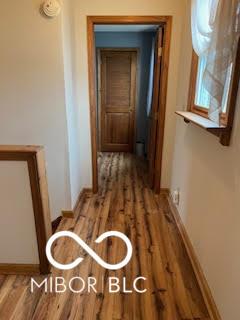 hall featuring wood finished floors and baseboards