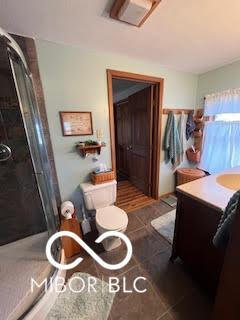 bathroom with tile patterned floors, vanity, and a shower stall