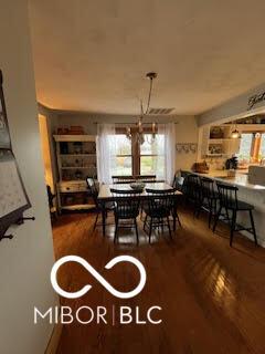 dining area featuring an inviting chandelier and wood finished floors