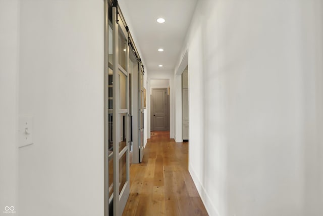 5130 Melbourne Pl, Zionsville, IN 46077 - hallway featuring a barn door, recessed lighting, and light wood-style flooring