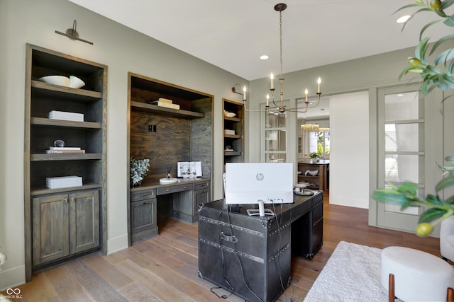 5130 Melbourne Pl, Zionsville, IN 46077 - office area with a chandelier, wood finished floors, and built in shelves