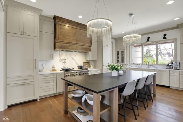 5130 Melbourne Pl, Zionsville, IN 46077 - kitchen featuring double oven range, custom range hood, recessed lighting, tasteful backsplash, and wood finished floors