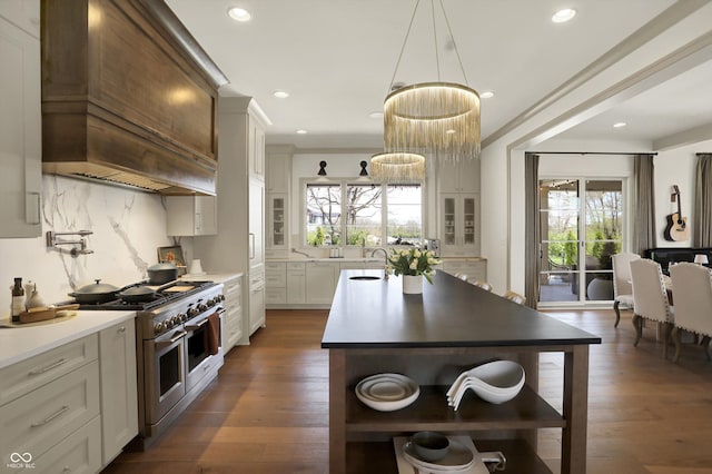 5130 Melbourne Pl, Zionsville, IN 46077 - kitchen with range with two ovens, custom range hood, healthy amount of natural light, an island with sink, and recessed lighting