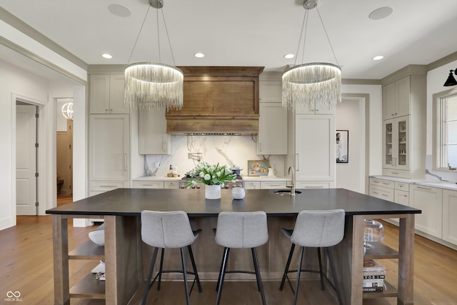 5130 Melbourne Pl, Zionsville, IN 46077 - kitchen with tasteful backsplash, dark countertops, recessed lighting, wood finished floors, and an island with sink