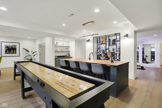 5130 Melbourne Pl, Zionsville, IN 46077 - indoor wet bar featuring light wood finished floors, recessed lighting, hanging light fixtures, and baseboards
