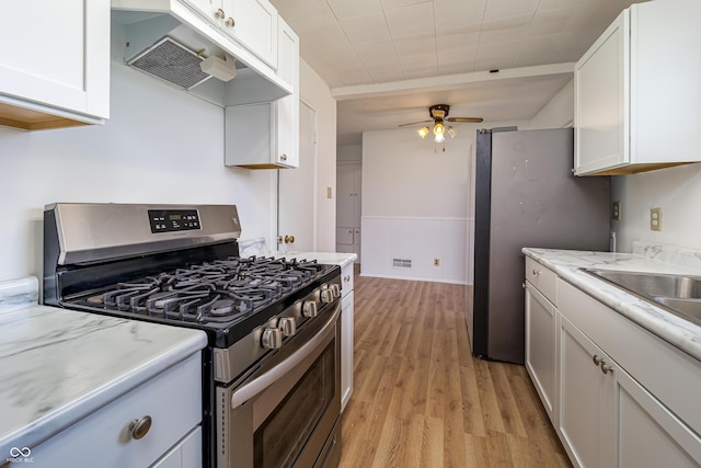 3510 Chamberlin Dr, Indianapolis, IN 46237 - kitchen with light wood-type flooring, white cabinetry, appliances with stainless steel finishes, and under cabinet range hood