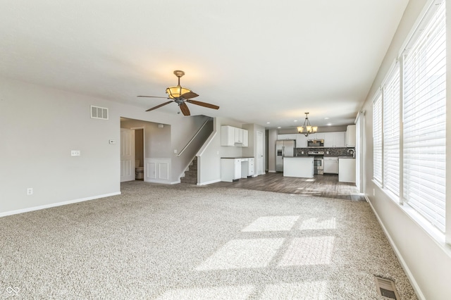 4747 Summit Lake Pl, Indianapolis, IN 46239 - unfurnished living room with ceiling fan with notable chandelier, carpet, stairway, and visible vents