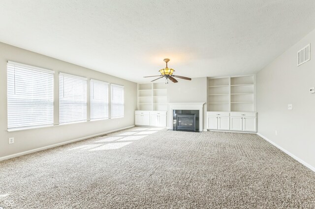 4747 Summit Lake Pl, Indianapolis, IN 46239 - unfurnished living room featuring a fireplace with flush hearth, a textured ceiling, visible vents, baseboards, and a ceiling fan