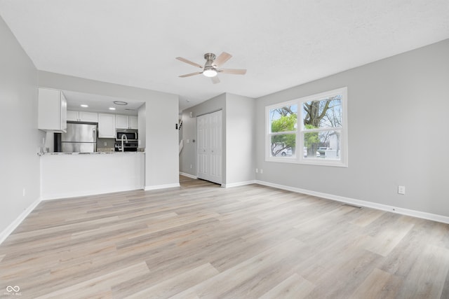 6059 S Bay Dr, Indianapolis, IN 46250 - unfurnished living room featuring baseboards, ceiling fan, visible vents, and light wood-type flooring