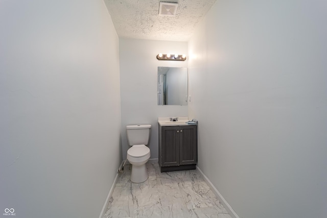2134 Dawson St, Indianapolis, IN 46203 - half bath featuring visible vents, vanity, marble finish floor, baseboards, and a textured ceiling