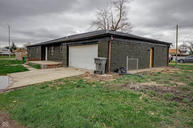 2134 Dawson St, Indianapolis, IN 46203 - view of side of home featuring concrete driveway, brick siding, and an attached garage