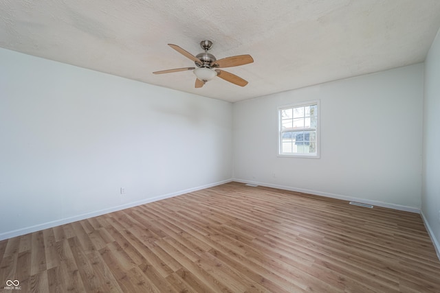 2134 Dawson St, Indianapolis, IN 46203 - spare room featuring baseboards, visible vents, ceiling fan, and light wood-style floors