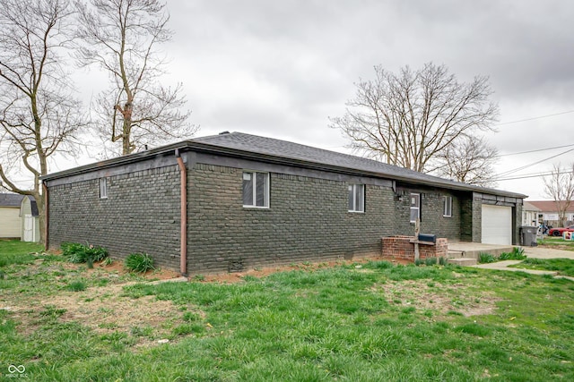 2134 Dawson St, Indianapolis, IN 46203 - view of side of home with a garage, a lawn, driveway, and brick siding