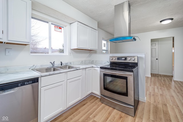 2134 Dawson St, Indianapolis, IN 46203 - kitchen featuring appliances with stainless steel finishes, a sink, light wood-style flooring, white cabinetry, and island exhaust hood