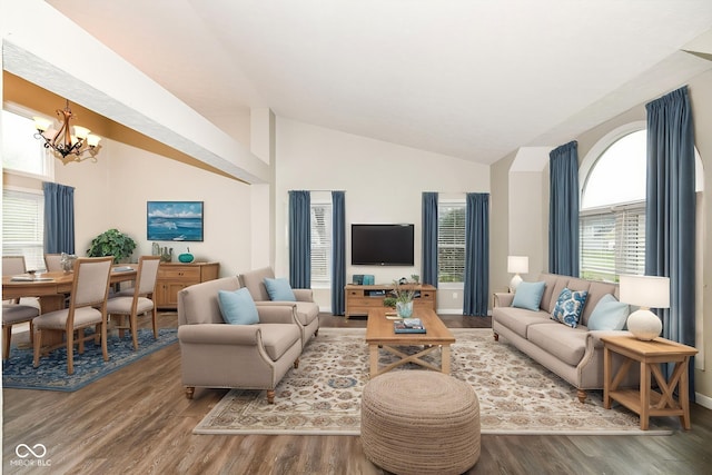 living area with lofted ceiling, an inviting chandelier, and wood finished floors