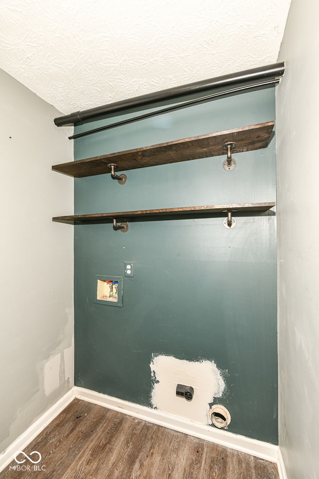 laundry area featuring baseboards, a textured ceiling, washer hookup, laundry area, and wood finished floors