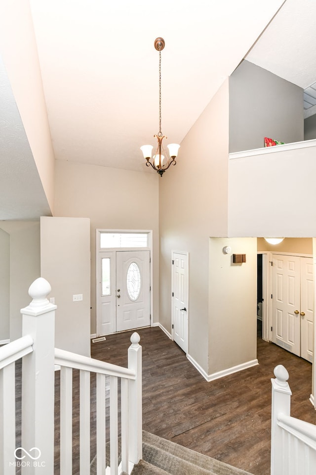 entrance foyer with high vaulted ceiling, baseboards, a chandelier, and wood finished floors