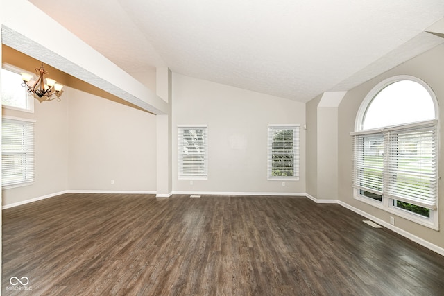 unfurnished room with an inviting chandelier, visible vents, vaulted ceiling, dark wood-style flooring, and baseboards