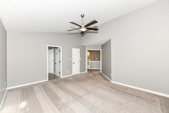 unfurnished bedroom with baseboards, ceiling fan, a textured ceiling, carpet floors, and lofted ceiling