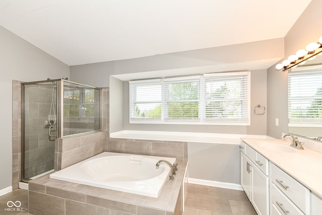 bathroom with a bath, plenty of natural light, vanity, and a stall shower