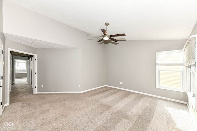 unfurnished room featuring ceiling fan, light colored carpet, baseboards, and a textured ceiling