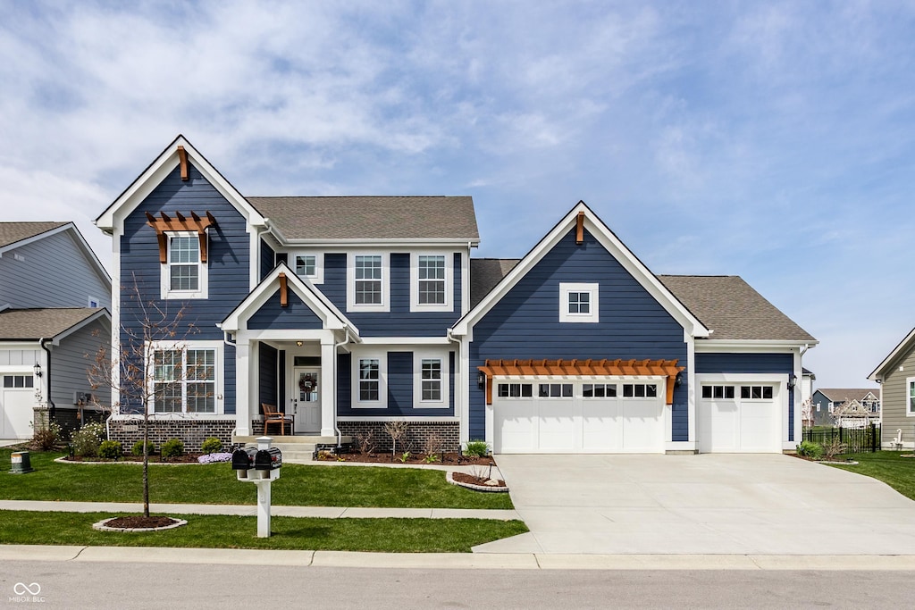 craftsman-style home featuring a garage, a front yard, and concrete driveway