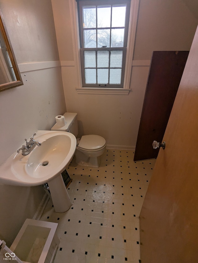 bathroom featuring tile patterned floors, toilet, and a sink