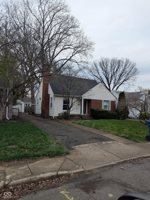 view of front of home featuring a front lawn and a chimney