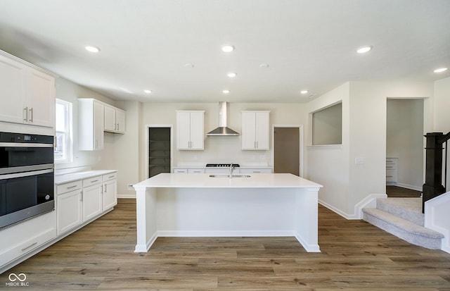 3241 Fawn Cir, Brownsburg, IN 46112 - kitchen with wall chimney range hood, a sink, double oven, white cabinetry, and recessed lighting