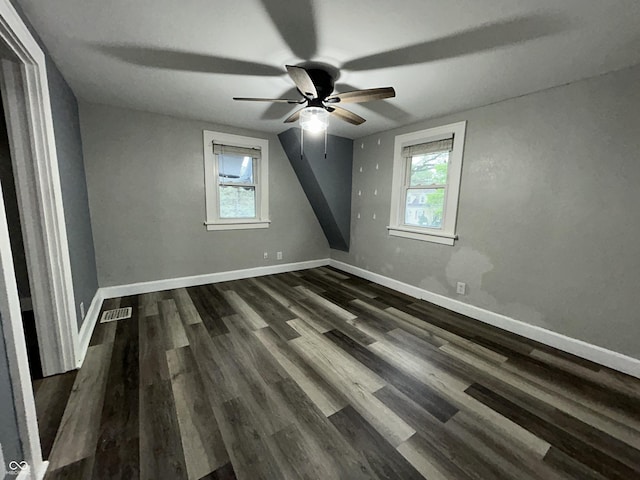 1627 E 8th St, Anderson, IN 46012 - unfurnished bedroom with multiple windows, baseboards, and dark wood-style floors