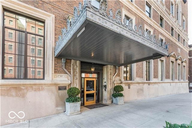 view of exterior entry featuring brick siding