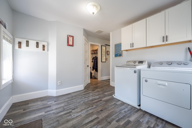 clothes washing area with baseboards, cabinet space, dark wood finished floors, and independent washer and dryer