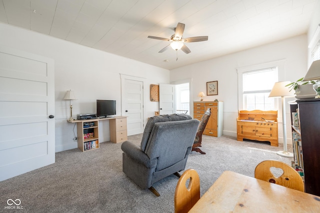 living room with carpet floors, baseboards, and ceiling fan