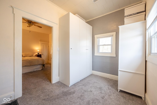 carpeted bedroom with a closet and crown molding