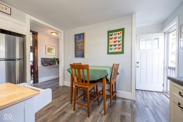 dining room featuring dark wood-type flooring and baseboards