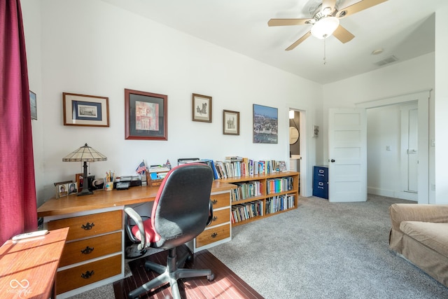 carpeted office featuring visible vents and a ceiling fan