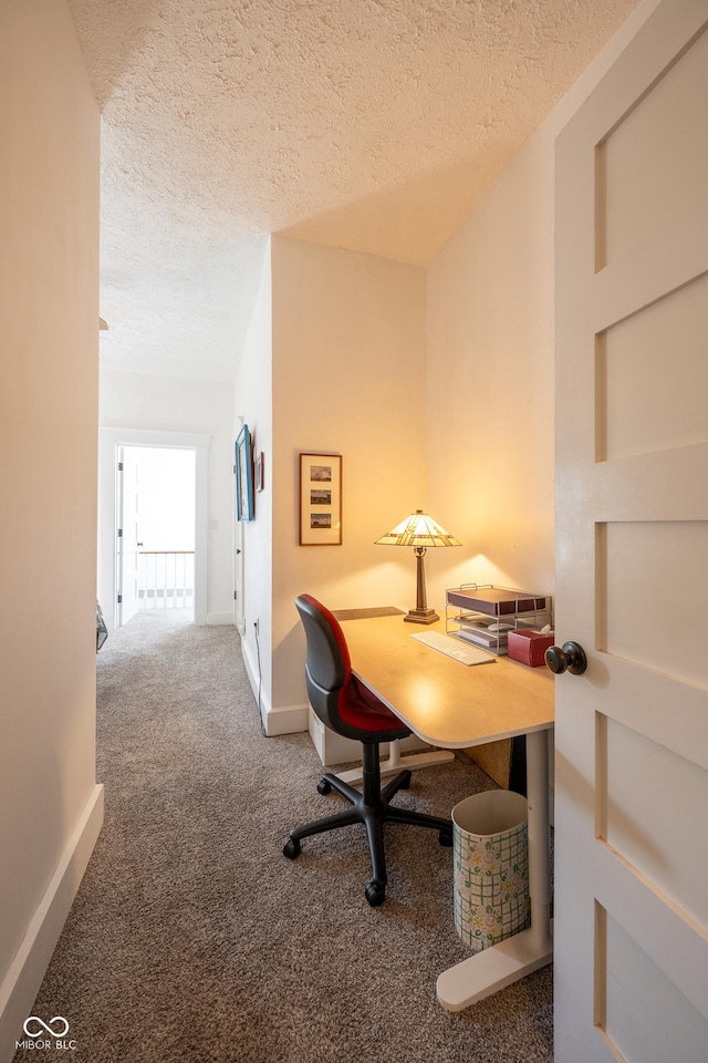 carpeted office featuring baseboards and a textured ceiling