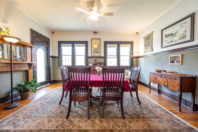 dining room featuring baseboards, a ceiling fan, wood finished floors, and ornamental molding